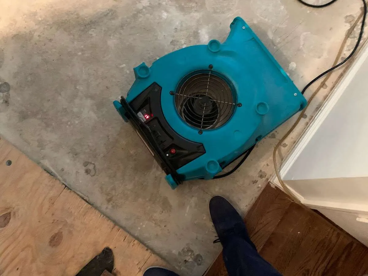 Air mover drying subfloor during Commercial Water Damage Restoration in Fort Atkinson